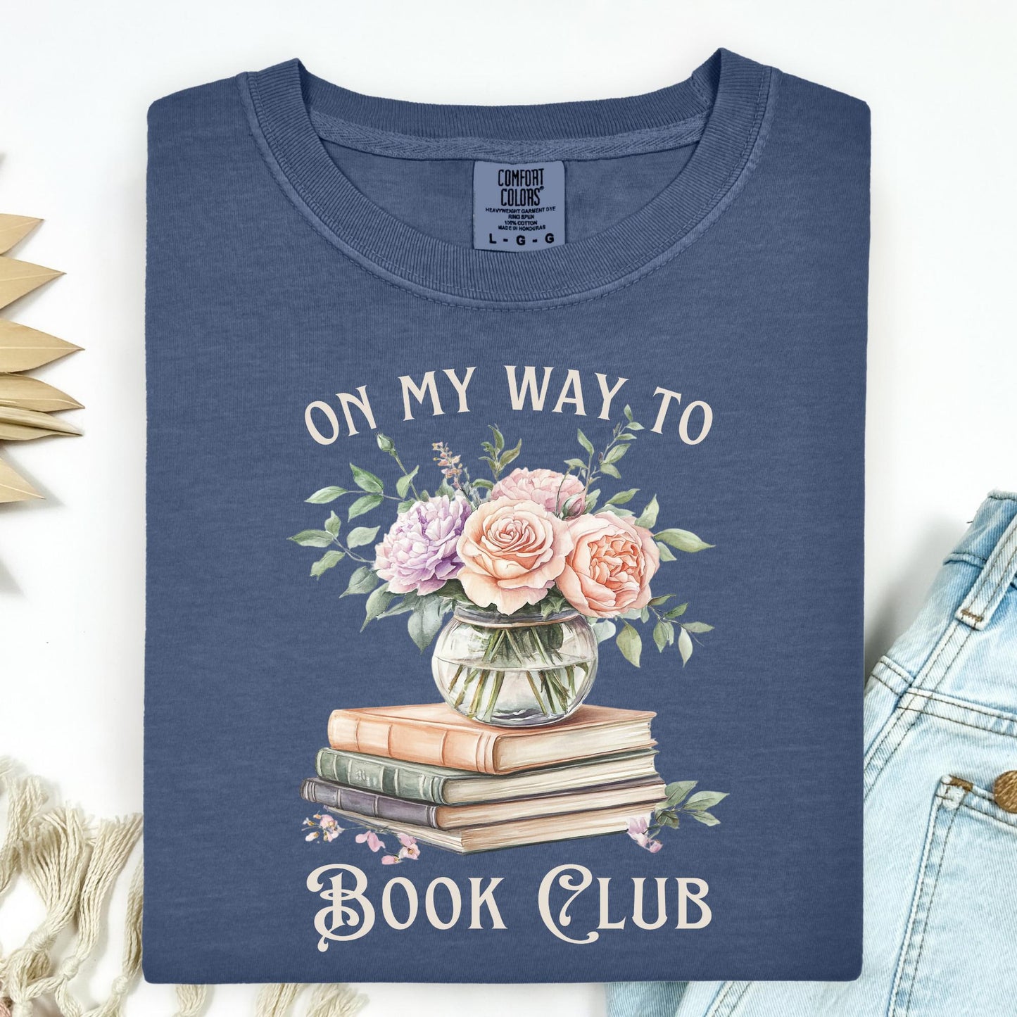 Denim t-shirt with "On My Way To Book Club" text, watercolor vintage books, and a vase of pink flowers.