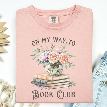 Peachy Comfort Colors tee with "On My Way to Book Club" text, watercolor vintage books, and floral vase design.
