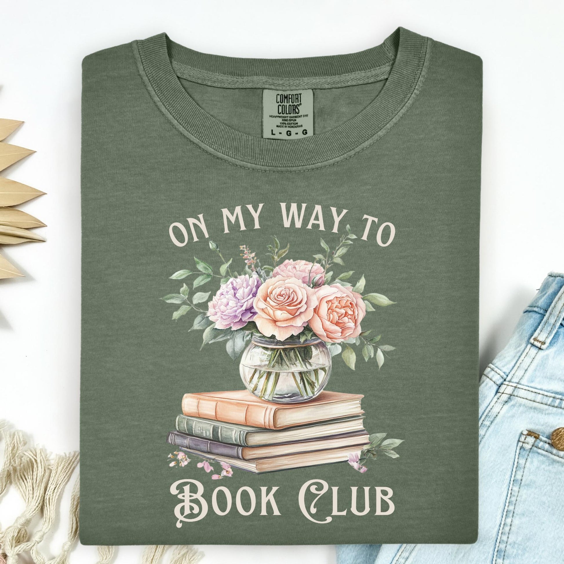 Moss green "On My Way To Book Club" t-shirt with watercolor vintage books and floral vase design.