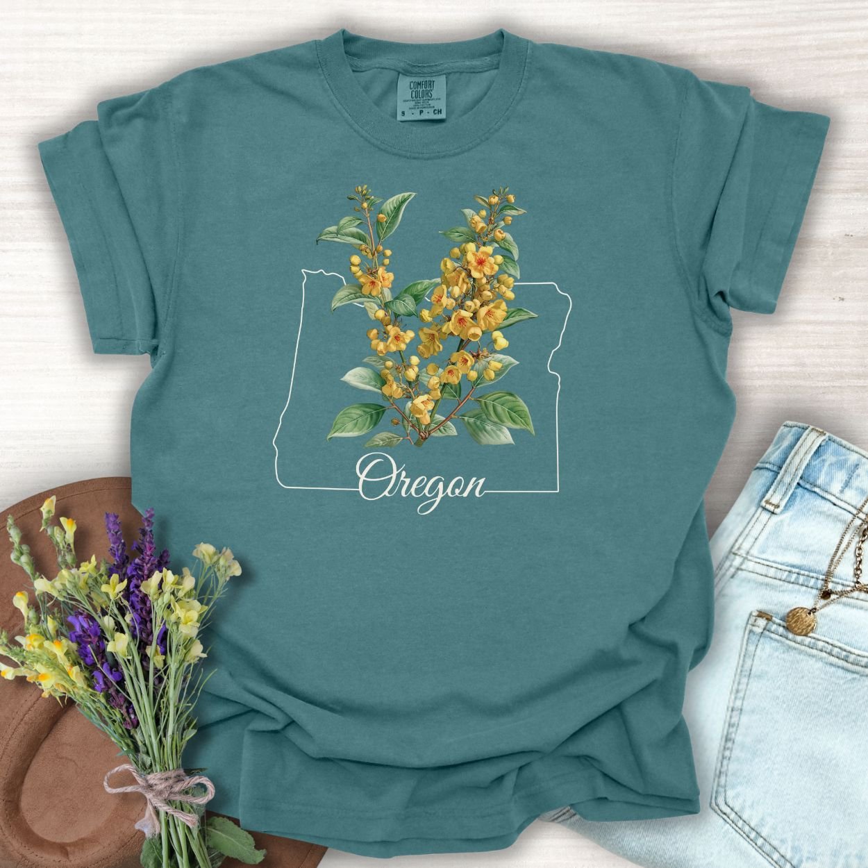 Blue Spruce S-size t-shirt with a white Oregon outline and warm yellow Oregon Grape Blossom design.