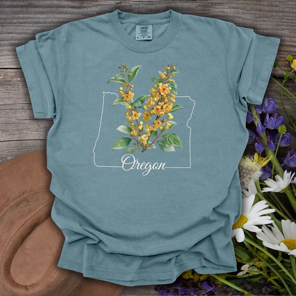 Ice Blue S t-shirt with a hand-drawn Oregon outline, "Oregon" text, and warm yellow Oregon Grape blossoms.