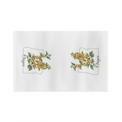 White microfiber tea towel with two Oregon state outlines filled with golden Oregon Grape blossoms.