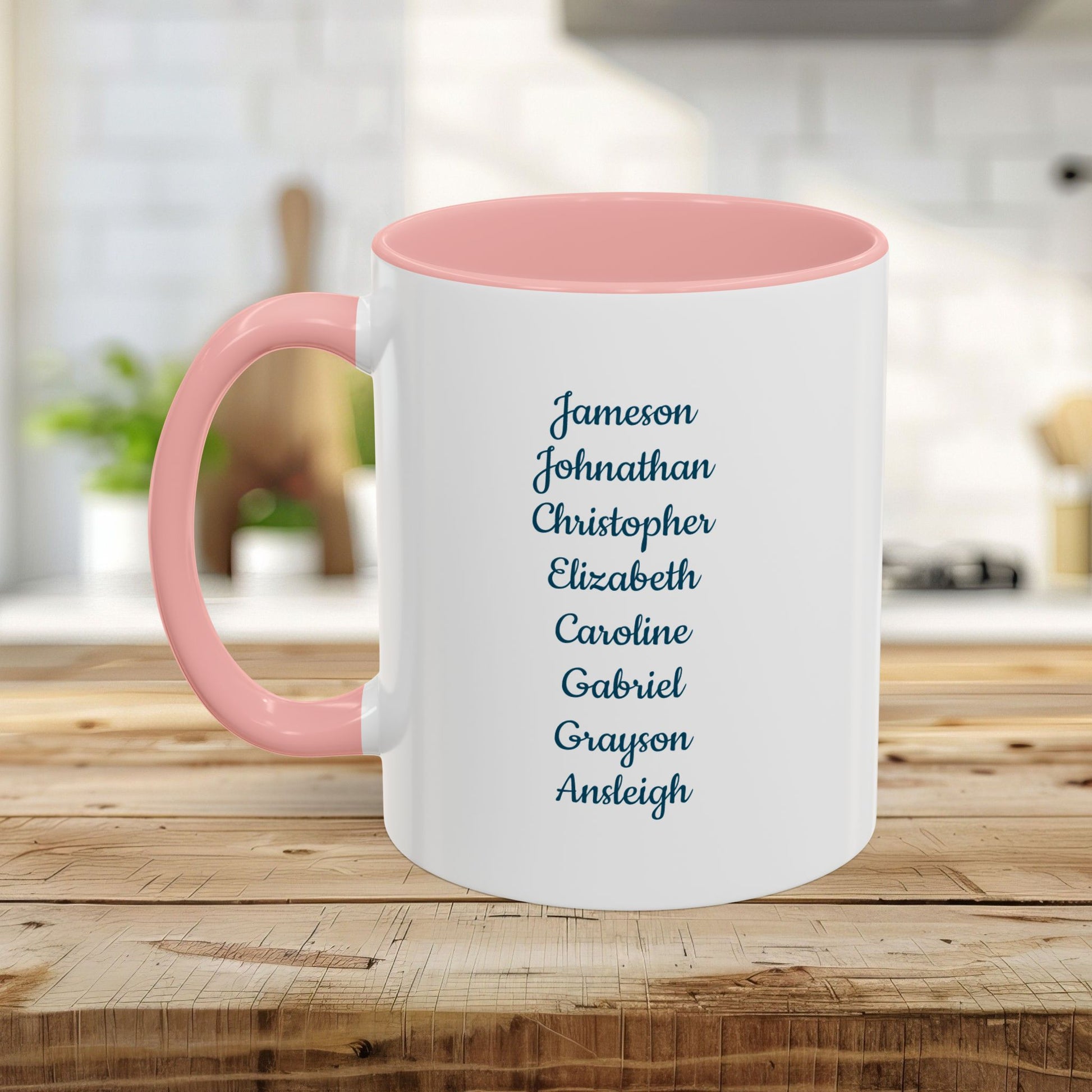 Personalized white ceramic mug with pink handle and interior, featuring a list of names in blue script.