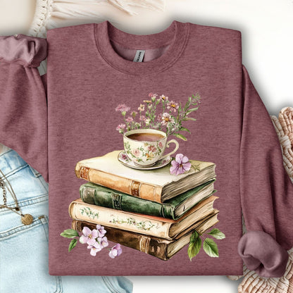 Heather Sport Dark Maroon sweatshirt with stacked pastel books, floral teacup, and greenery illustration.