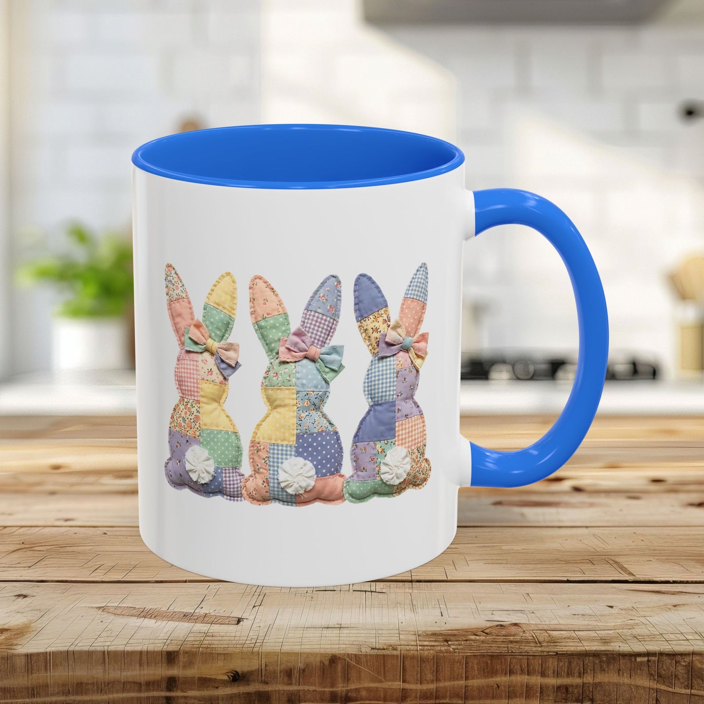 White ceramic mug with Cambridge Blue interior and handle, featuring three pastel patchwork bunnies.