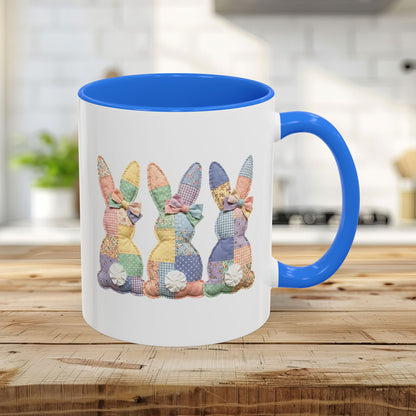 White ceramic mug with Cambridge Blue interior and handle, featuring three pastel patchwork bunnies.