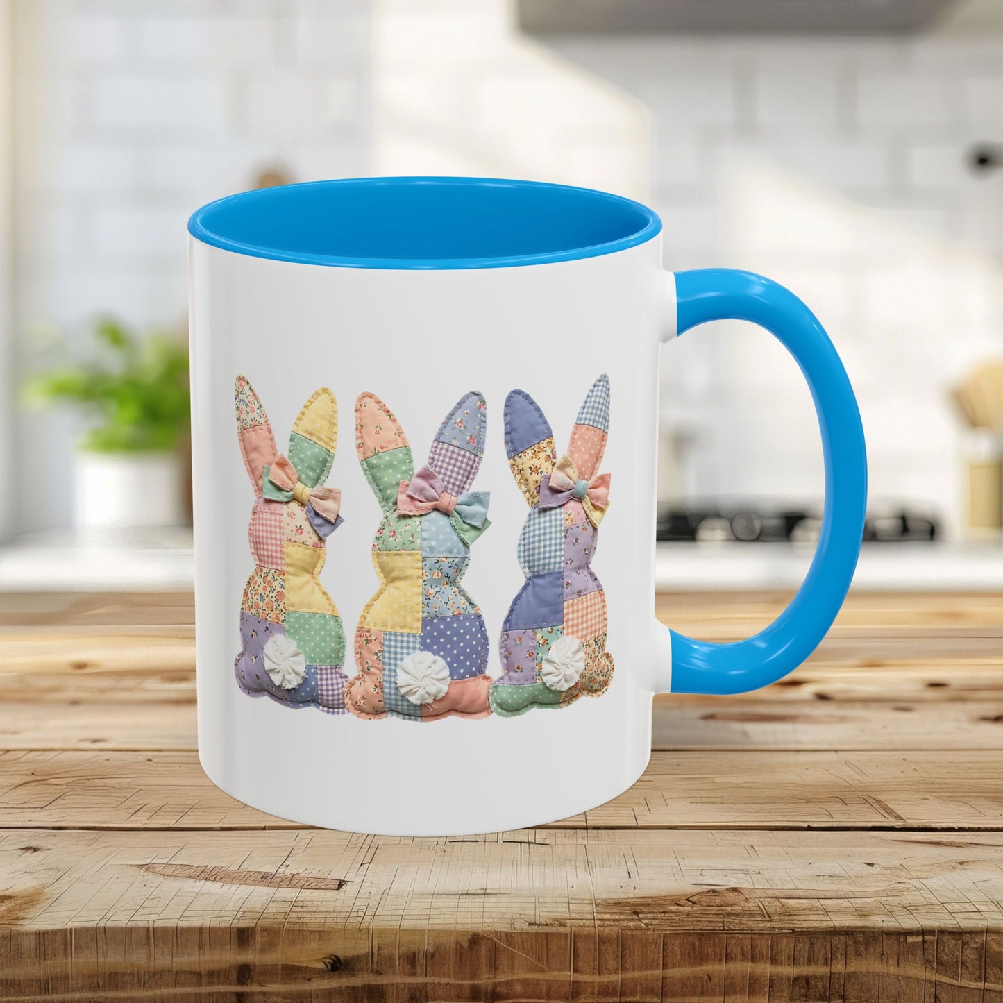 White 11oz ceramic mug with light blue interior and handle, featuring three pastel patchwork bunnies.