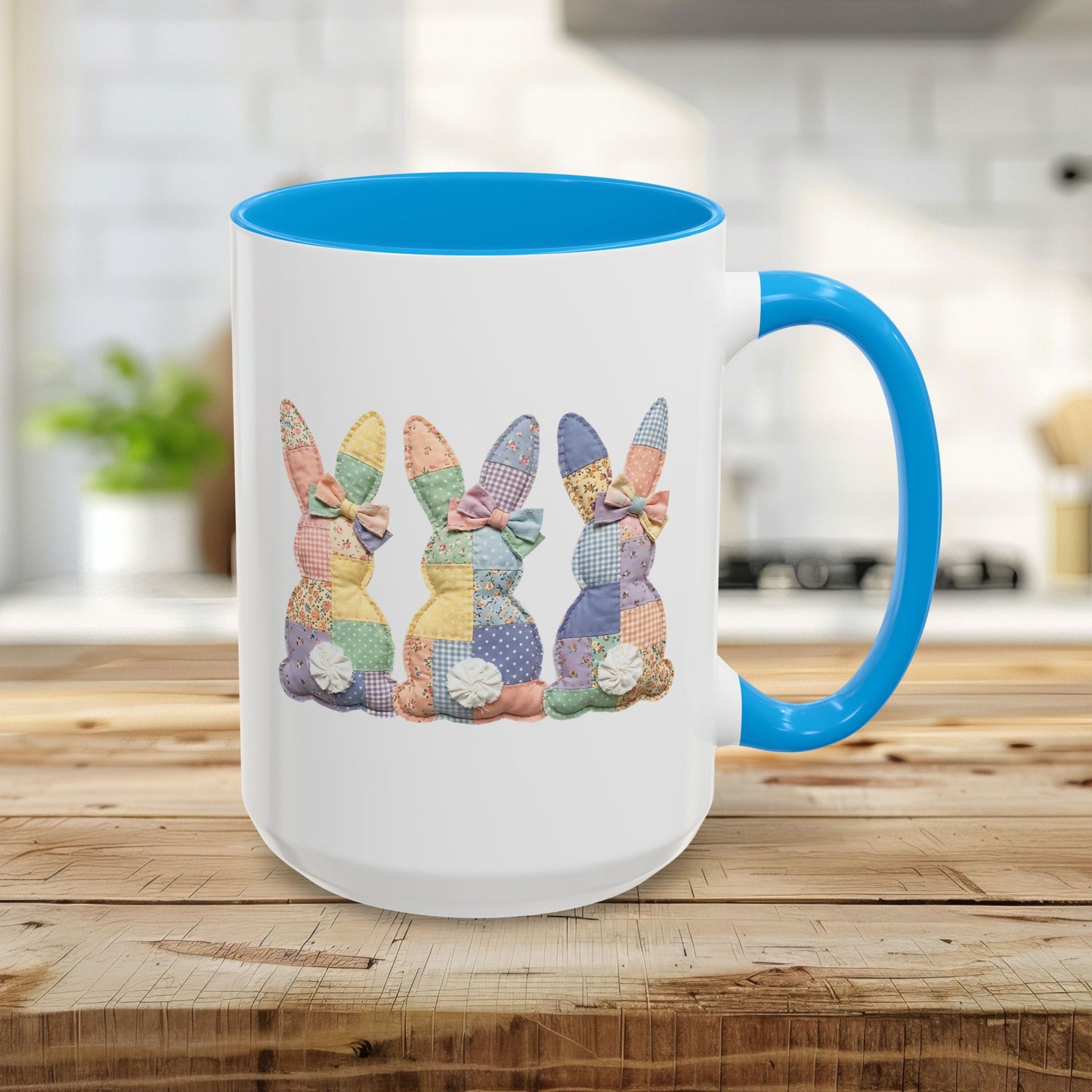15oz white ceramic mug with light blue interior and handle, featuring three pastel patchwork bunnies.