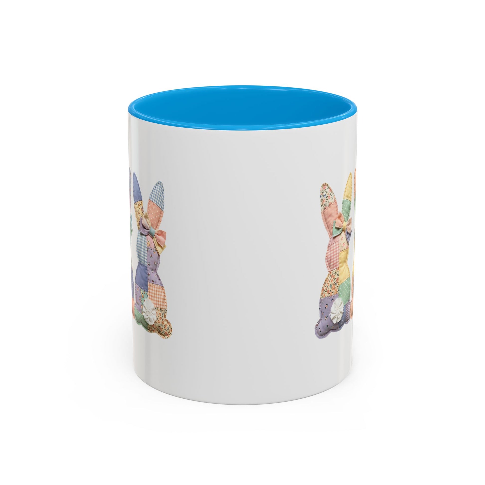 White ceramic mug with a blue interior and handle, featuring pastel patchwork bunny designs.