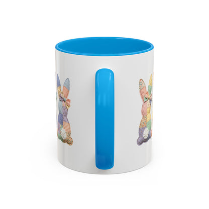 White ceramic 11oz mug with blue handle and interior, featuring pastel patchwork bunny tails design.