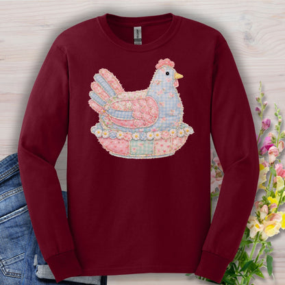 Maroon long-sleeve cotton tee with a pastel faux patchwork hen in a nest of flowers.