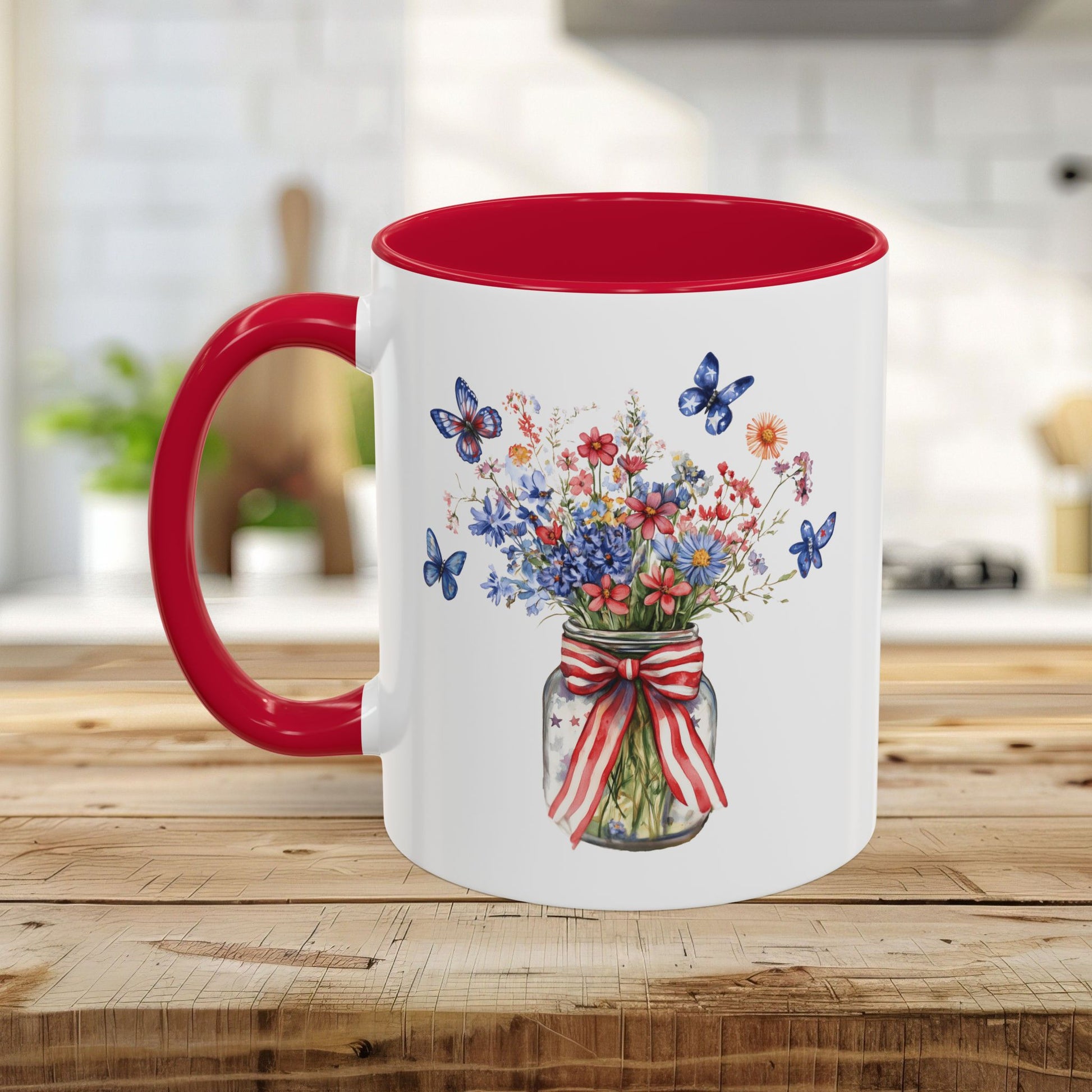 White ceramic mug with red interior and handle, featuring a watercolor mason jar bouquet with patriotic flowers and blue butterflies.