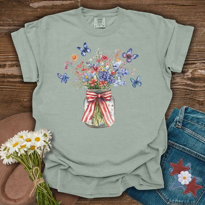 Bay S t-shirt with a watercolor mason jar of wildflowers, patriotic ribbon, and butterflies.