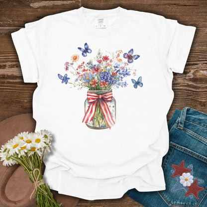 White S t-shirt with watercolor wildflowers in a mason jar with a patriotic ribbon and blue butterflies.