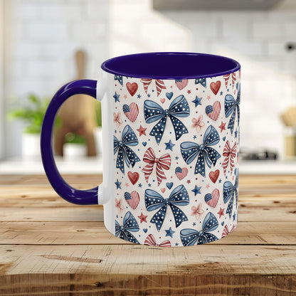 White ceramic mug with patriotic bows, hearts, and stars pattern; purple interior and C-shaped handle.