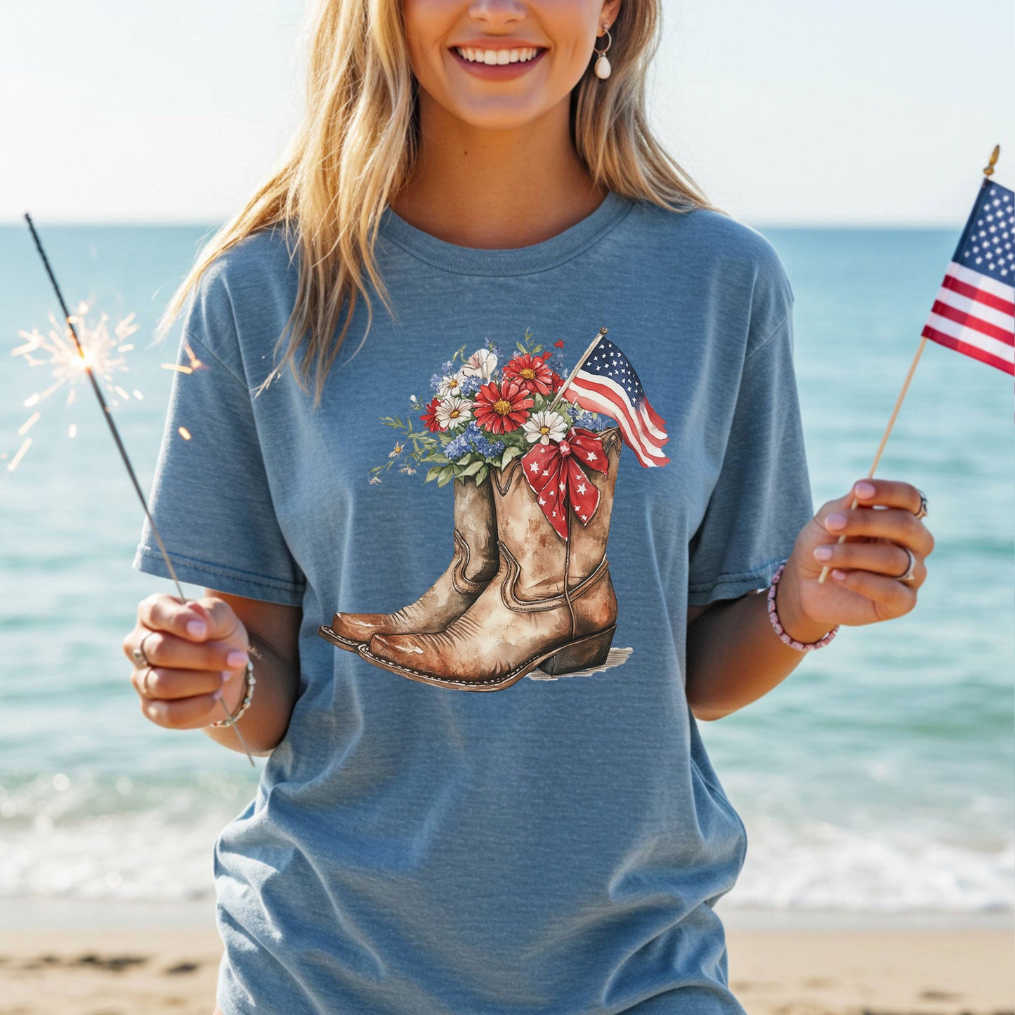 Garment-dyed blue t-shirt with watercolor cowboy boots, flowers, and an American flag design.