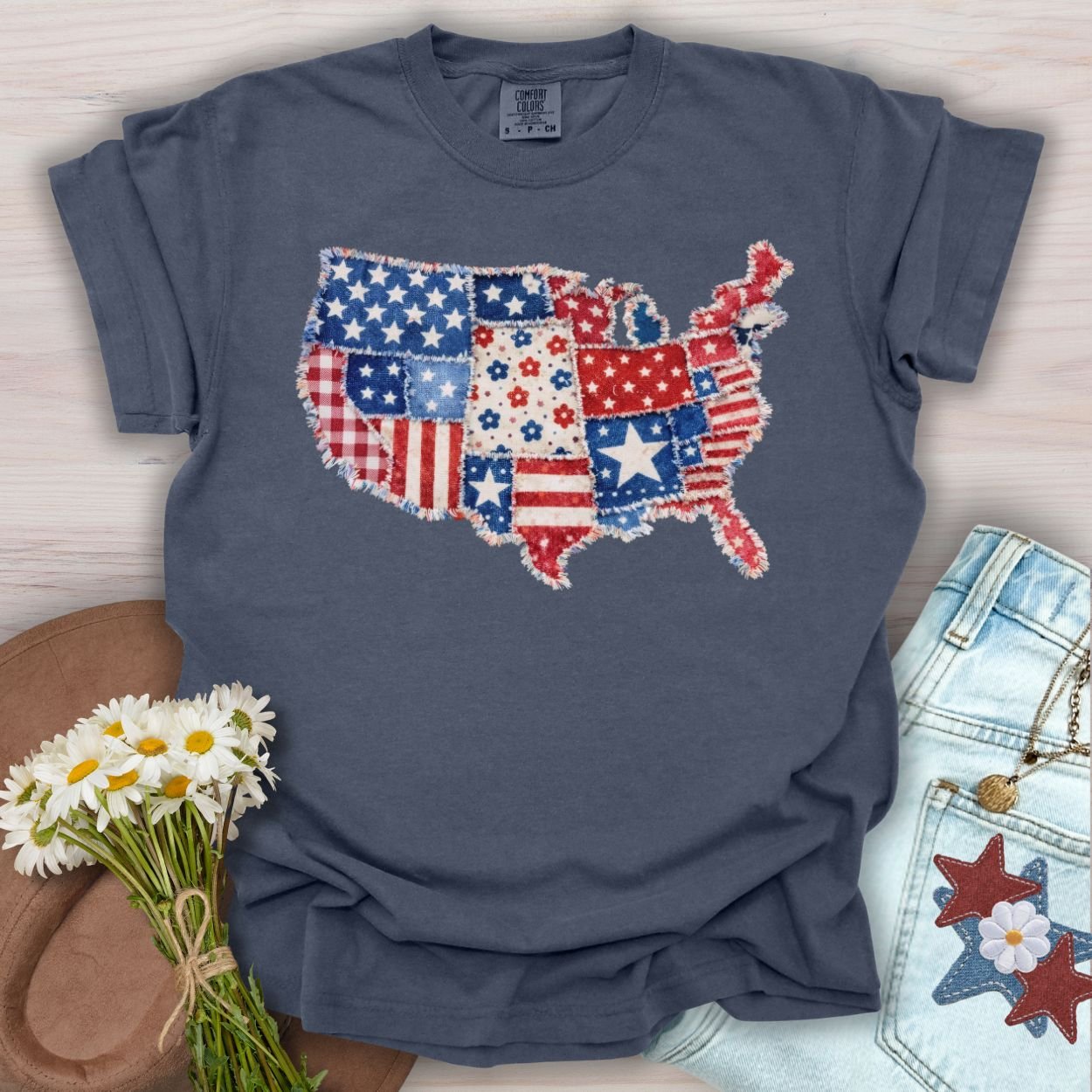 Denim S t-shirt with a printed faux patchwork map of America, featuring stars, stripes, and floral patterns.
