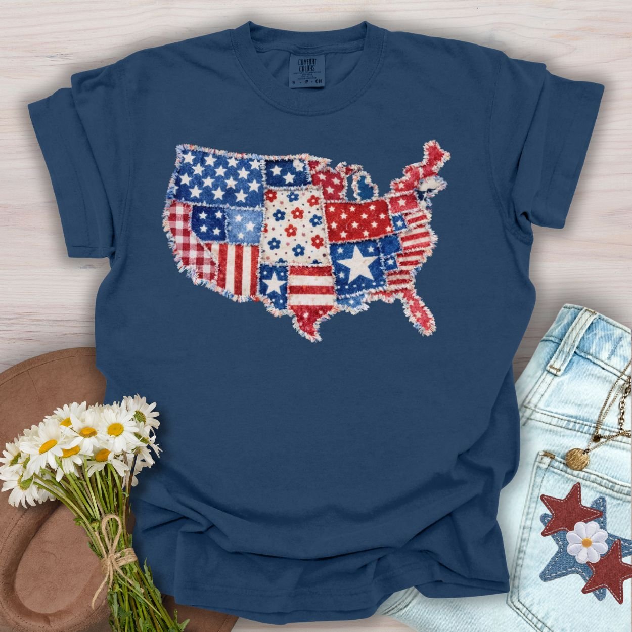 Navy S t-shirt with a printed faux patchwork US map in patriotic stars, stripes, and floral patterns.