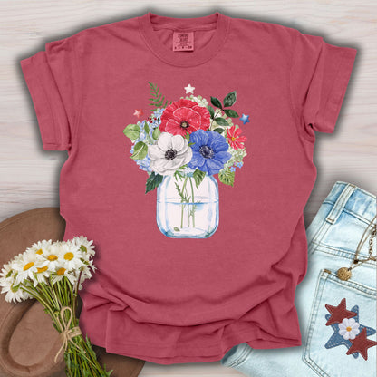 Crimson S t-shirt with a watercolor patriotic floral bouquet in a mason jar, featuring red, white, and blue anemones and stars.