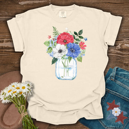 Ivory S t-shirt with a watercolor patriotic floral bouquet in a mason jar, featuring red, white, and blue anemones and stars.