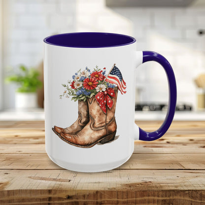 15oz ceramic mug with blue handle/interior, featuring watercolor cowboy boots, wildflowers, and an American flag.