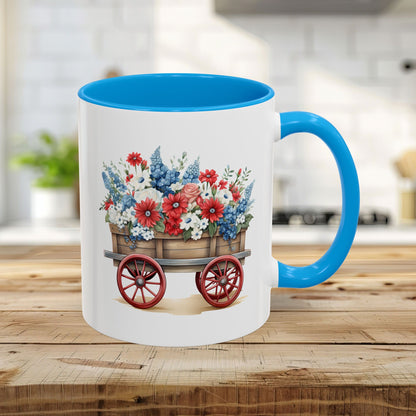 11oz ceramic mug with light blue handle/interior and a vintage wagon overflowing with patriotic red, white, and blue florals.