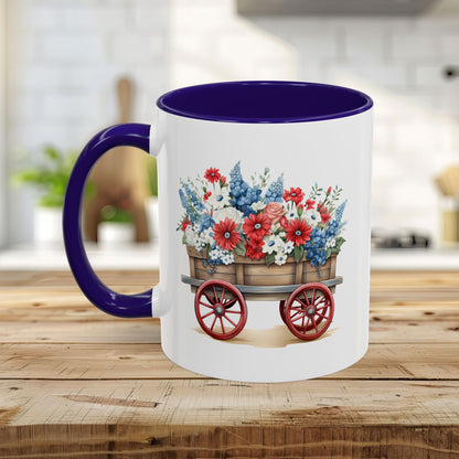 White ceramic mug with purple handle and interior, featuring a vintage wagon overflowing with red, white, and blue florals.