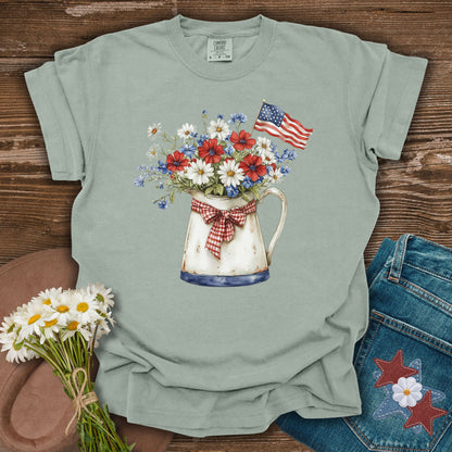 Green t-shirt with floral design and American flag on a wooden surface