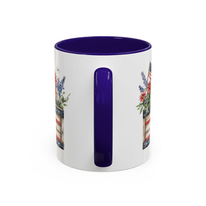White ceramic mug with blue handle and interior, featuring a patriotic garden box with daisies and lavender.