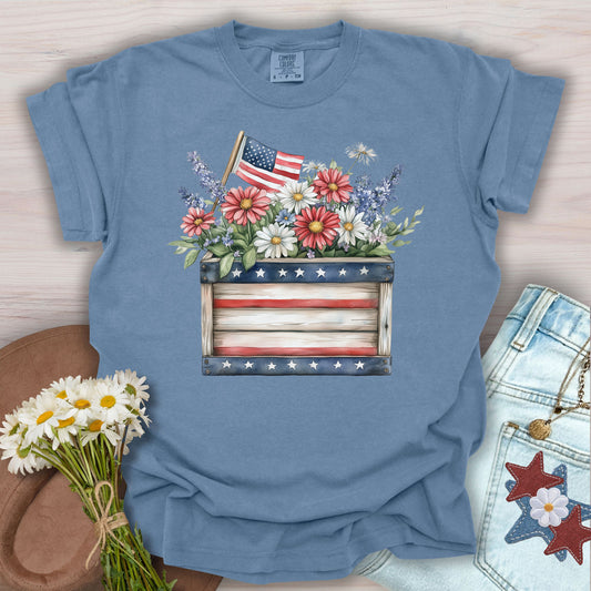 Blue Jean S garment-dyed cotton tee with watercolor patriotic gardening box, wildflowers, and US flag.