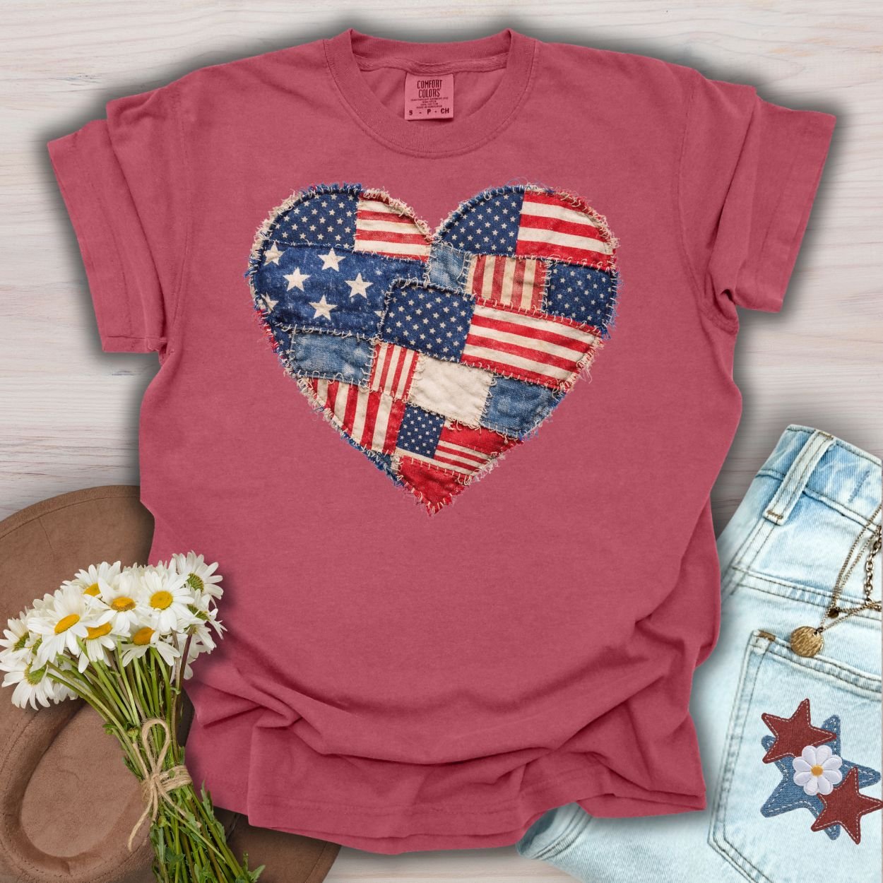 Crimson S t-shirt with a printed patchwork American flag heart design and frayed edges.