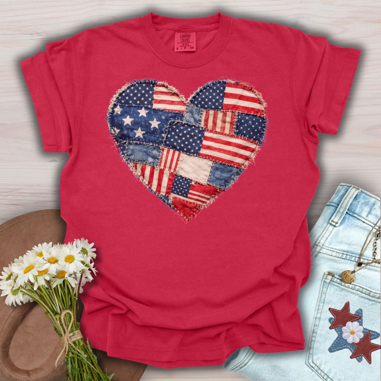 Red S t-shirt with a printed patchwork American flag heart design, featuring distressed fabric squares.