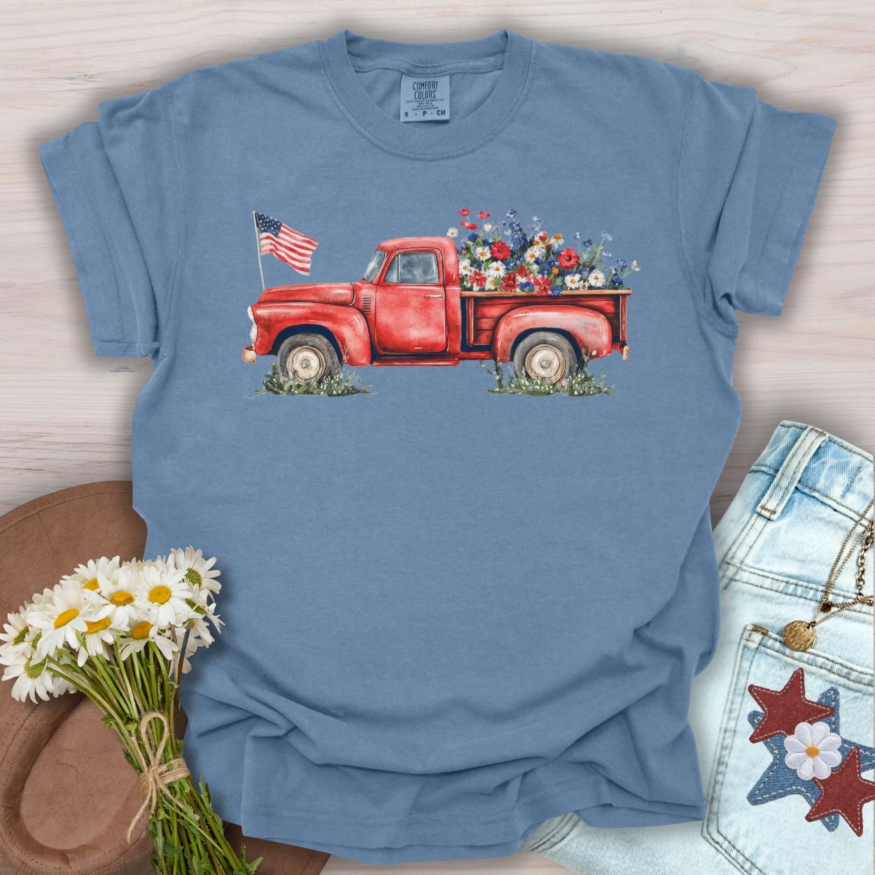 Blue Jean S t-shirt with a watercolor red pickup truck, wildflowers, and an American flag.