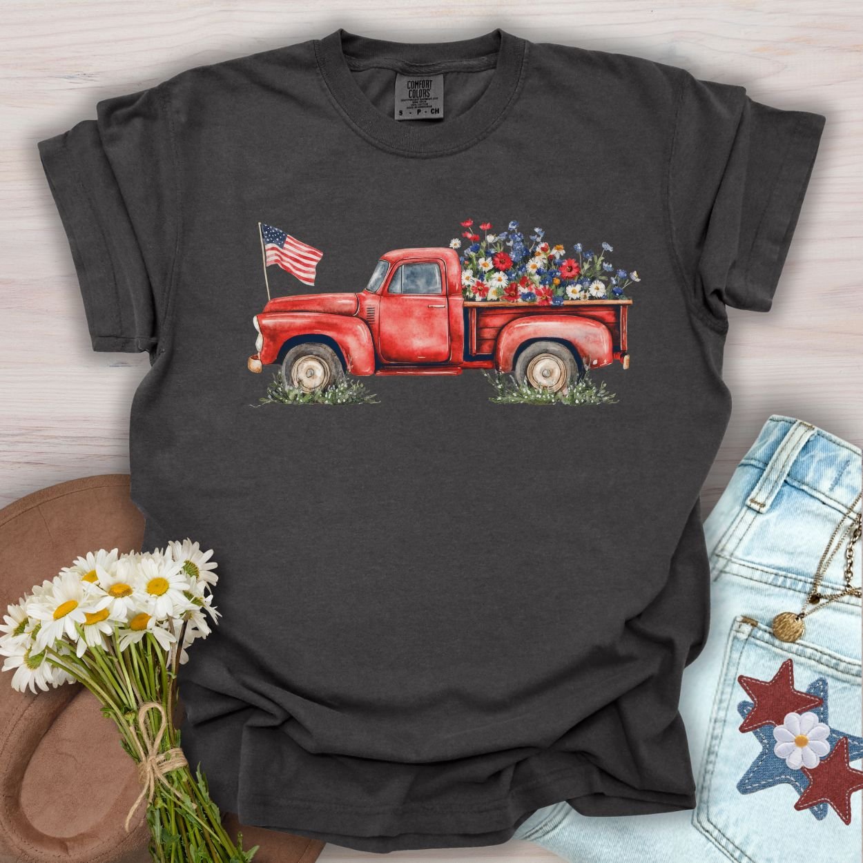 Pepper S t-shirt with a watercolor red pickup truck, wildflowers, and an American flag.