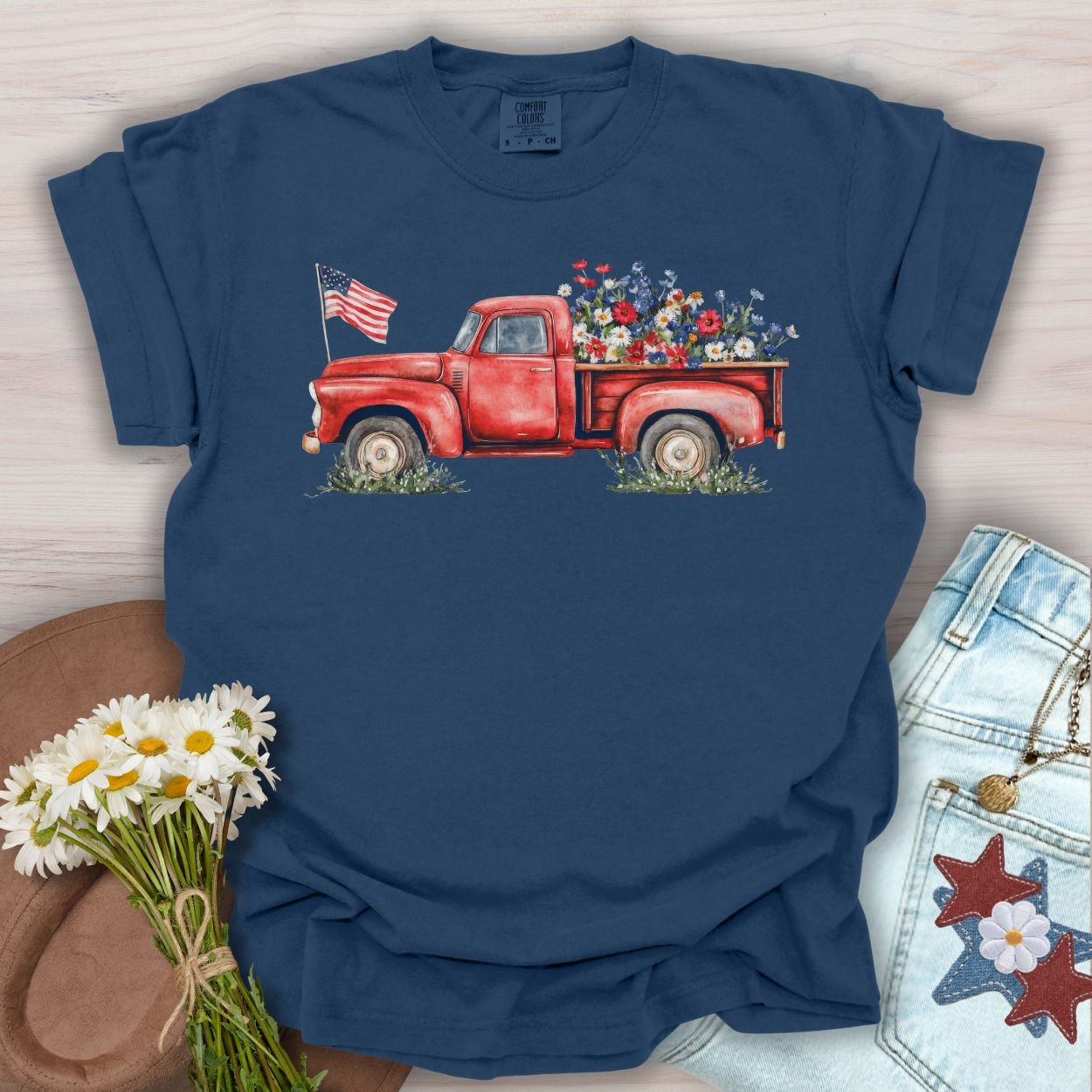 True Navy S t-shirt with a watercolor red pickup truck, wildflowers, and an American flag.