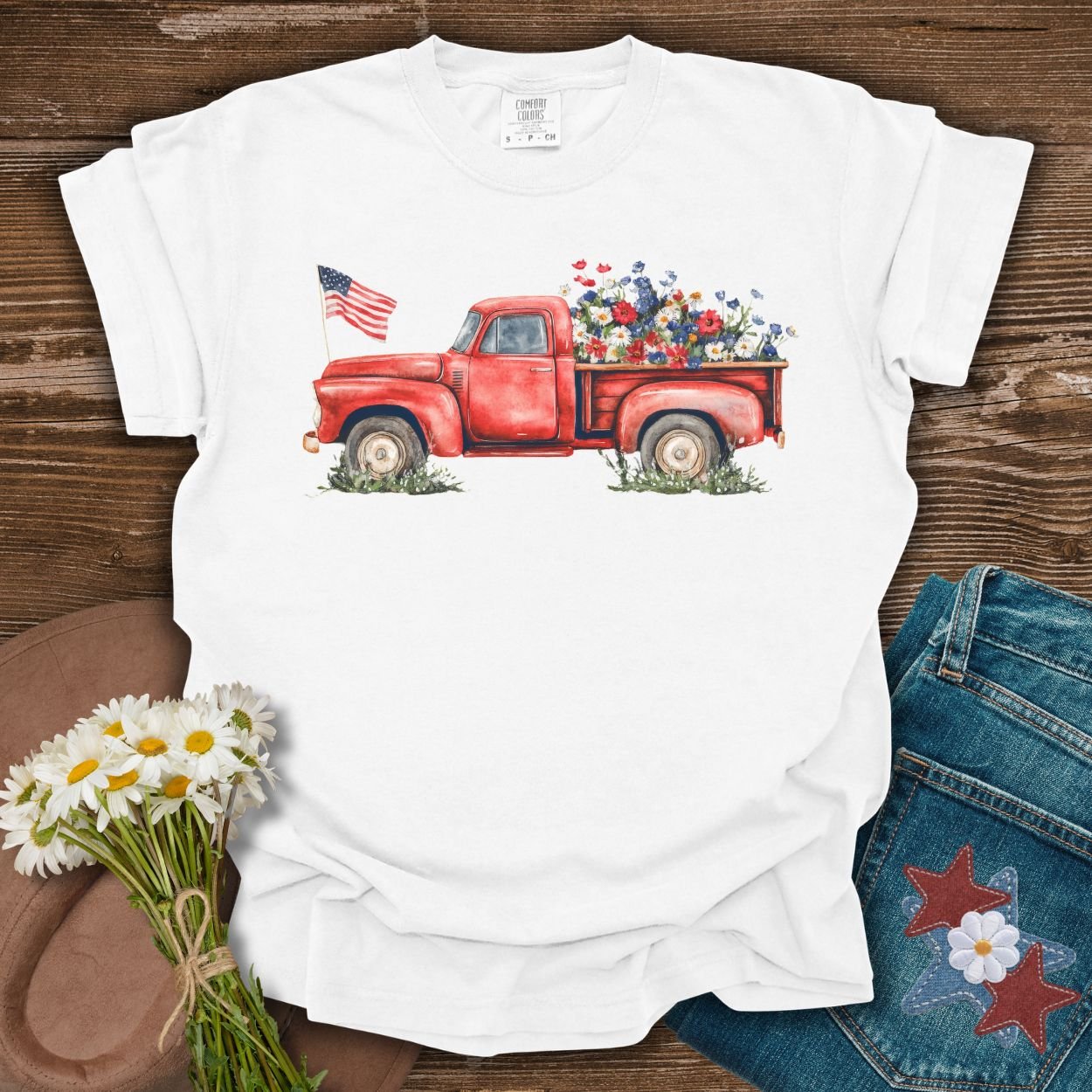 White S t-shirt with a watercolor red pickup truck, wildflowers, and an American flag.