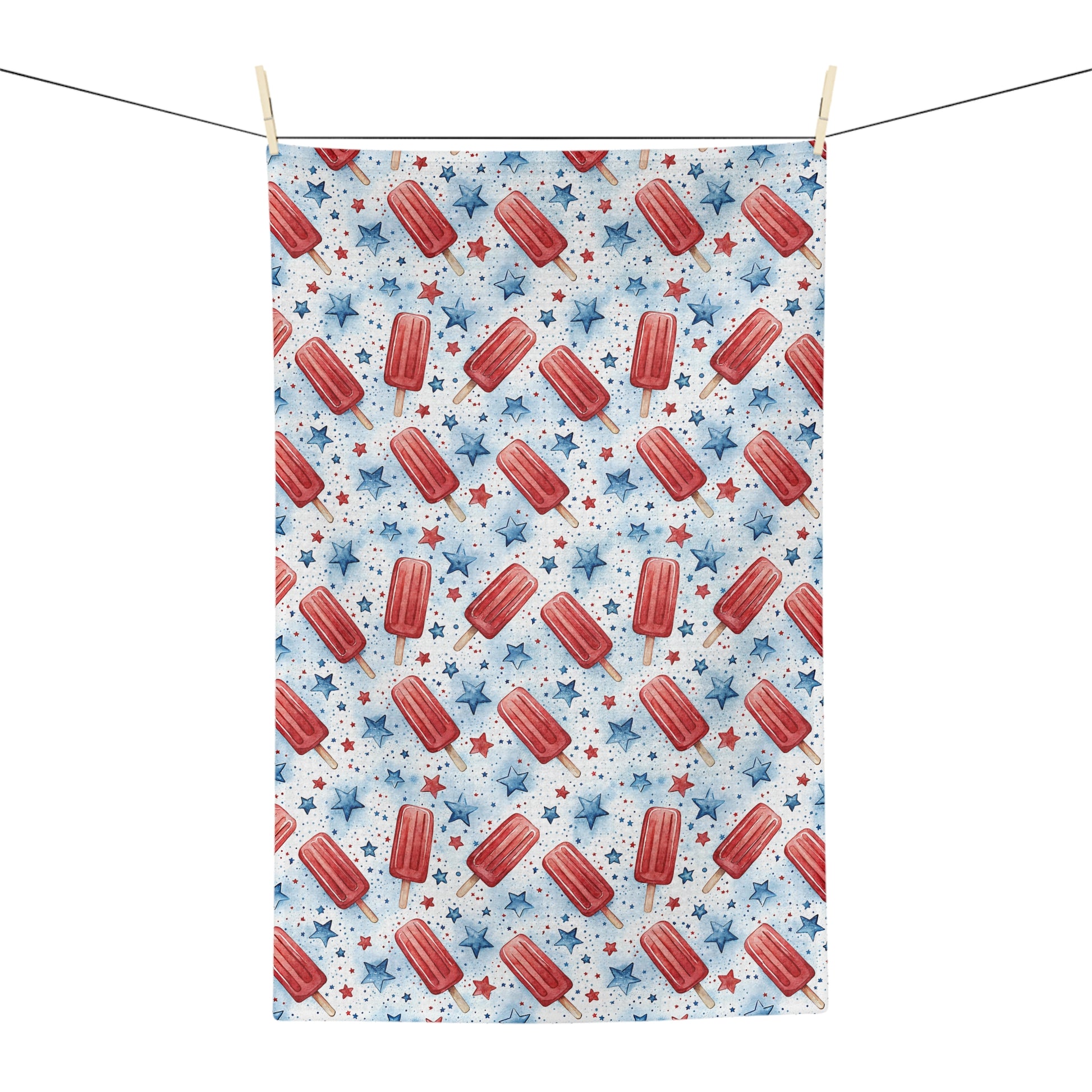 Microfiber tea towel with red popsicles and blue stars, hanging on a clothesline.