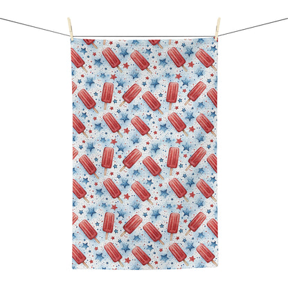 Microfiber tea towel with red popsicles and blue stars, hanging on a clothesline.