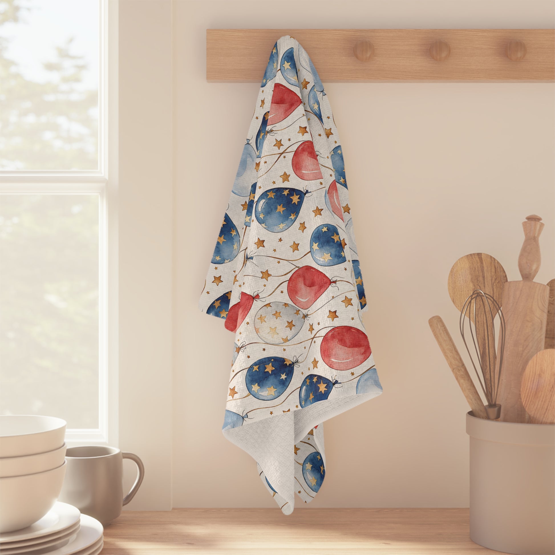 Patriotic microfiber tea towel with red, white, and blue balloons and golden stars, hanging on a wooden peg.