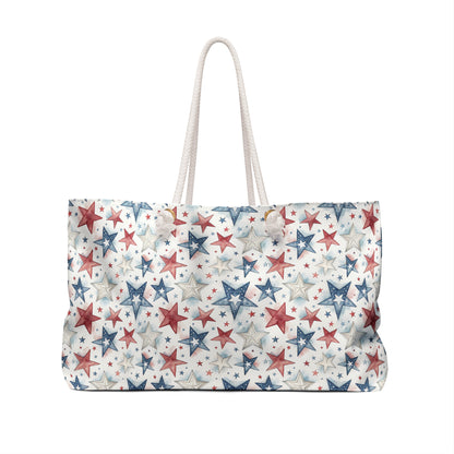Patriotic red, white, and blue star-patterned spun polyester weekender bag with cream rope handles.