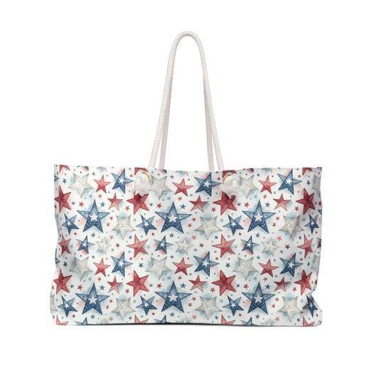 Spacious red, white, and blue star-patterned spun polyester weekender bag with cream rope handles.