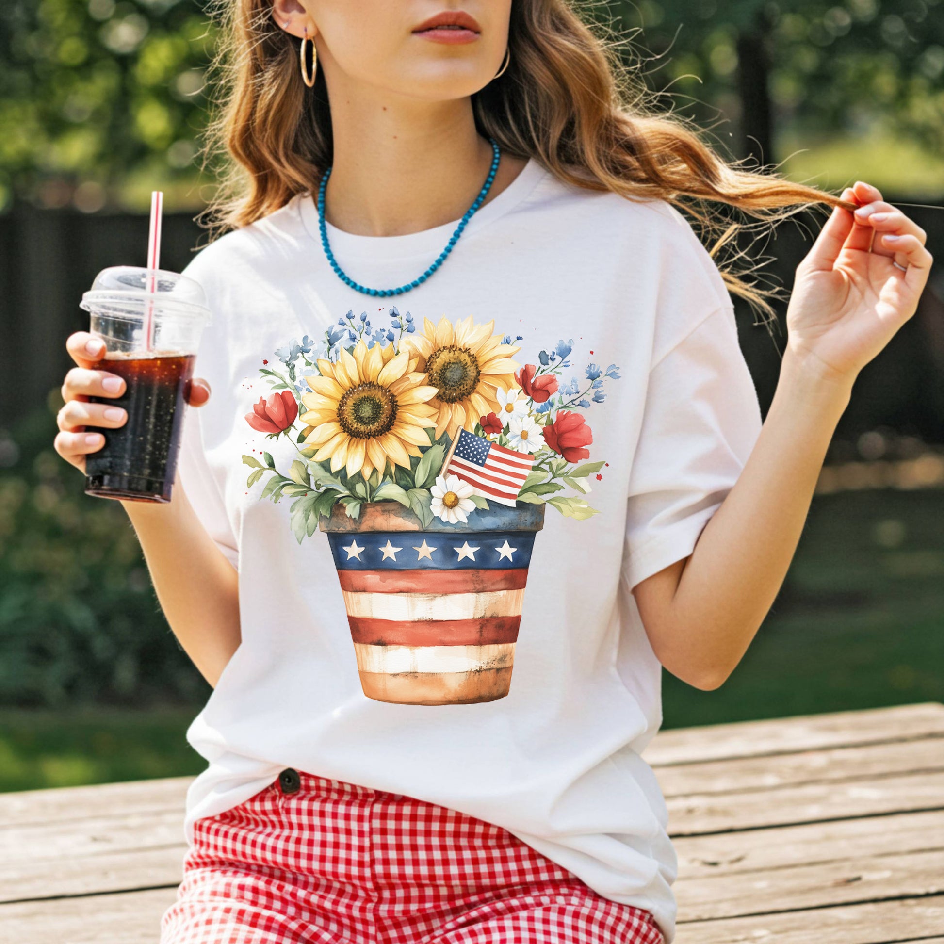 White t-shirt with a patriotic sunflower bouquet in an American flag pot, featuring daisies, roses, and blue forget-me-nots.