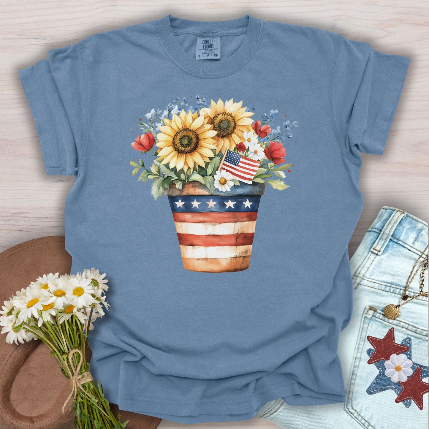 Blue Jean S t-shirt with a patriotic sunflower bouquet in an American flag pot, featuring daisies and roses.