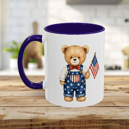 White ceramic mug with purple handle and interior, featuring a watercolor teddy bear in star-spangled overalls holding a US flag.