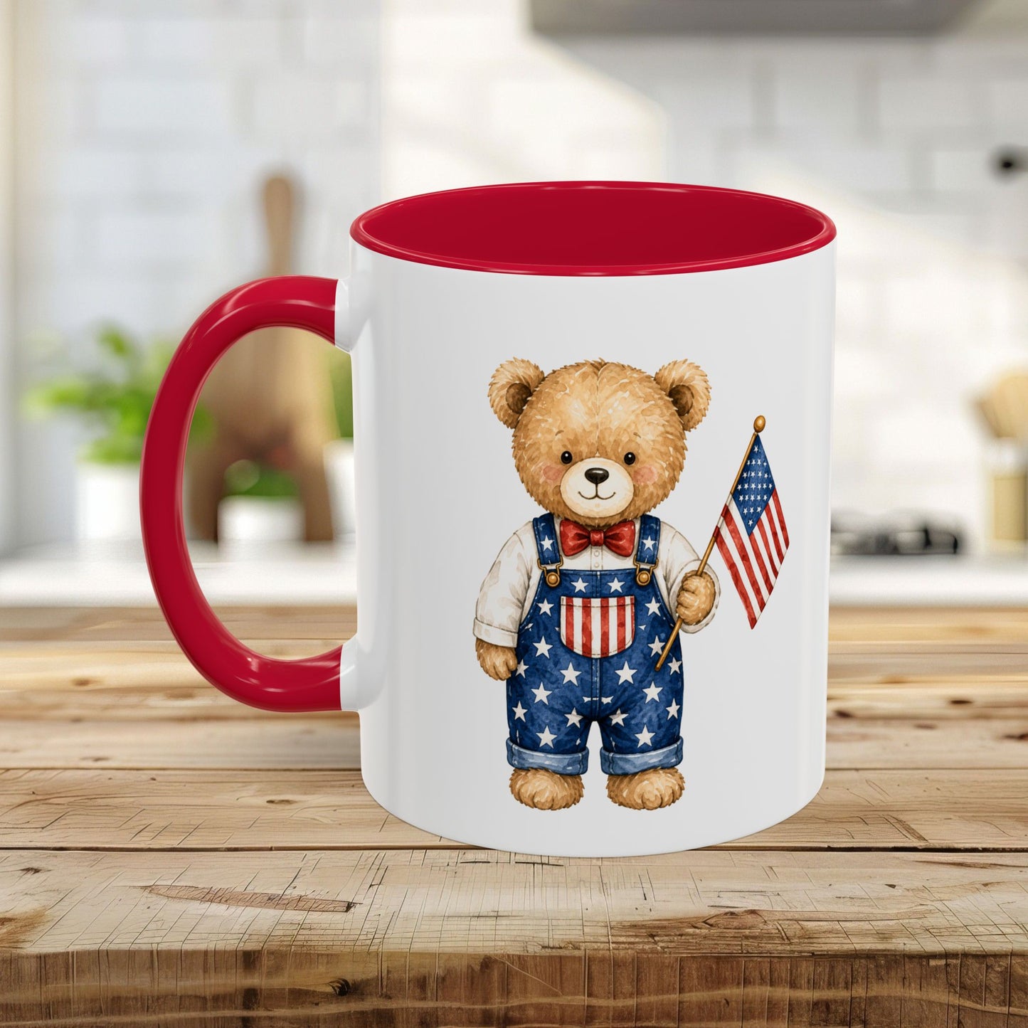 White ceramic mug with red interior and handle, featuring a watercolor teddy bear in star-spangled overalls holding a US flag.