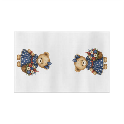 White microfiber tea towel with two teddy bears in star-dotted navy dresses holding red, white, and blue floral baskets.