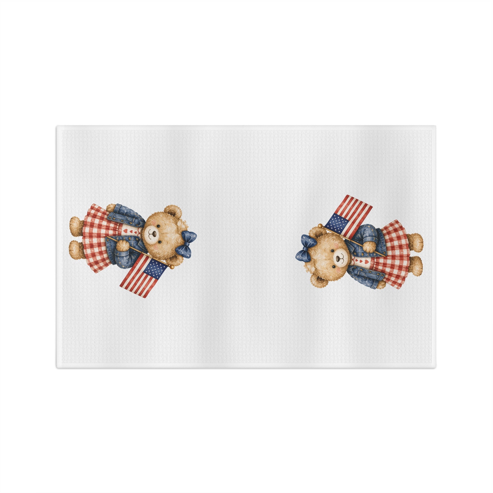 White microfiber tea towel with two teddy bears in red gingham dresses holding American flags.