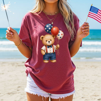 Woman in a relaxed-fit, garment-dyed red t-shirt with a vintage teddy bear holding star balloons.