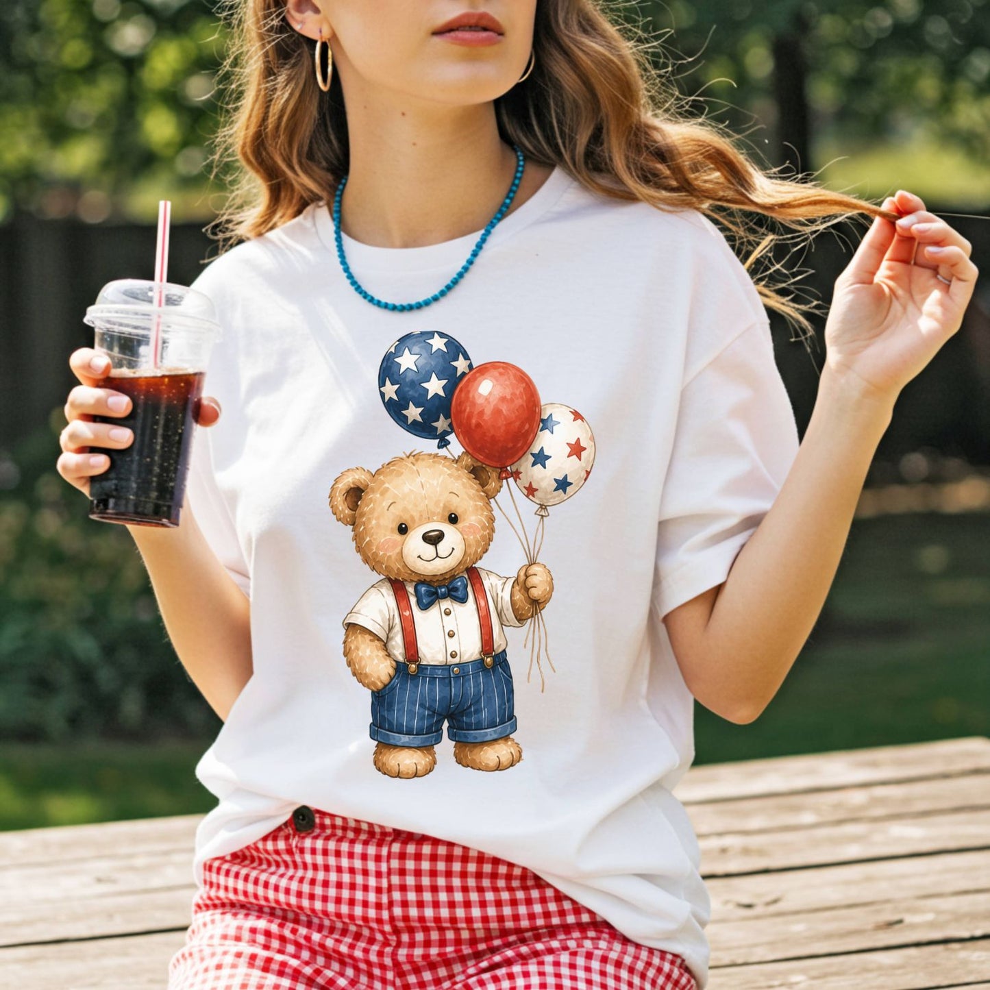 White cotton tee with a vintage teddy bear holding red, white, and blue star balloons.