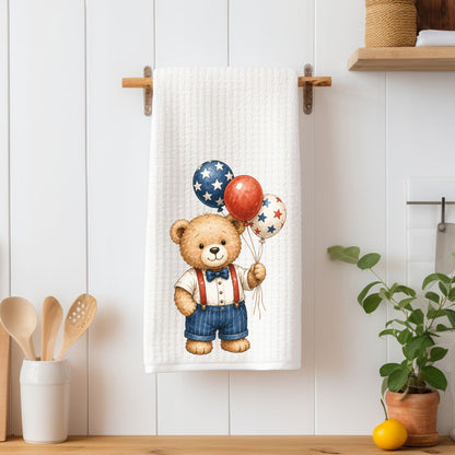 White microfiber tea towel with a vintage-style teddy bear holding red, white, and blue star balloons.